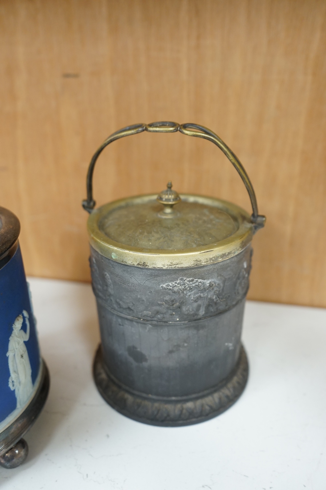A collection of Wedgwood comprising basalt and jasper biscuit barrels, an enamelled basalt teapot, and a cover and creamware basket, largest 26cm high (4)